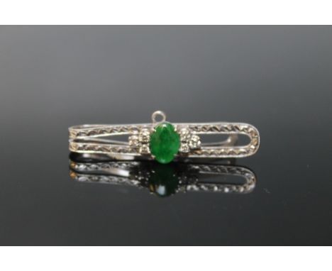 A JADE AND DIAMOND TIE SLIDE, the oval jade measuring 9 mm by 6 mm with six brilliant cut diamonds totalling approx 0.20 cara