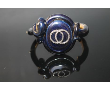 A DARK BLUE ENAMEL AND DIAMOND LOCKET SNAKE BANGLE, having a hinged catch set with two intertwined diamond chip circles