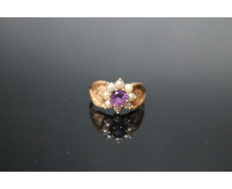 A 9 CARAT YELLOW GOLD AMETHYST AND PEARL RING, the central round amethyst being approx 0.70 carat surrounded by eight half pe