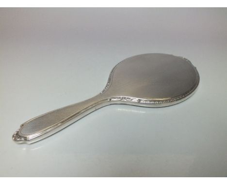 A HALLMARKED SILVER HAND MIRROR - BIRMINGHAM 1964, maker's mark for Adie Brothers, engine turned decoration to the reverse wi