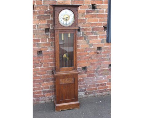 AN OAK CASED ART NOUVEAU LONGCASE CLOCK, the typical silvered dial with Arabic numerals, the trunk with a glazed door and car