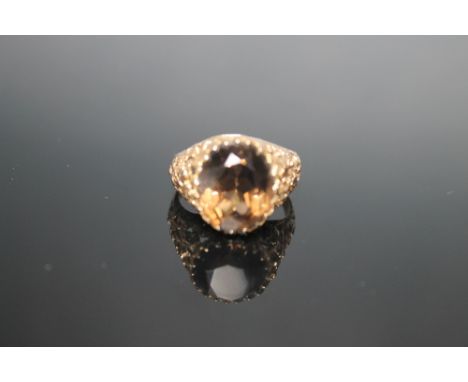 A 9 CARAT SMOKEY QUARTZ RING, measuring 14 mm by 12 mm, ring size R