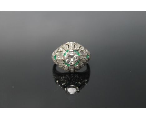 A DIAMOND AND EMERALD RING, set with a central diamond of appox 1 carat, surrounded by brilliant and baguette cut diamonds an