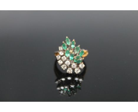 AN 18 CARAT EMERALD AND DIAMOND DRESS RING, set with eleven brilliant cut diamonds and nine marquise cut emeralds, ring size 