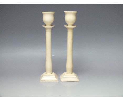 A PAIR OF 19TH CENTURY ANGLO INDIAN TURNED IVORY CANDLESTICKS, raised of square stepped bases, H 23 cmCondition Report:One st