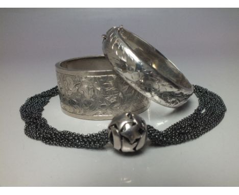 A HALLMARKED SILVER HINGED BANGLE, together with a similar larger example marked 600 fine, and an unusual necklace with hallm