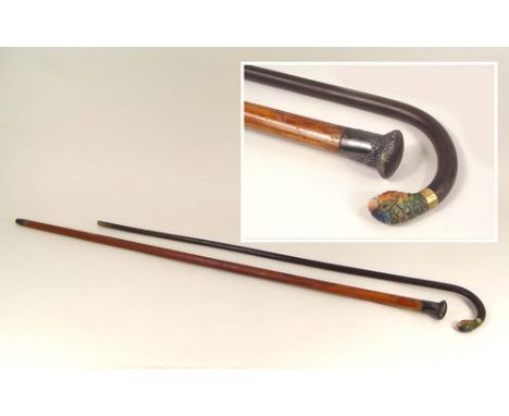WALKING CANES.
A silver mounted Malacca walking cane & a lady's walking stick with carved & painted parrot handle.