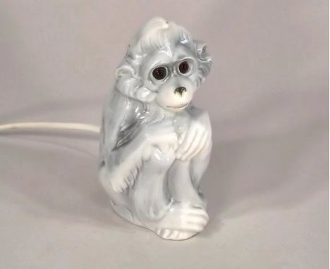 NIGHT LIGHT.
A continental porcelain monkey night light/pastille burner. Height 29cm.