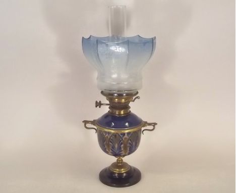 DOULTON OIL LAMP.
A brass mounted, Doulton stoneware oil lamp, with etched blue glass shade. Full height 52cm.