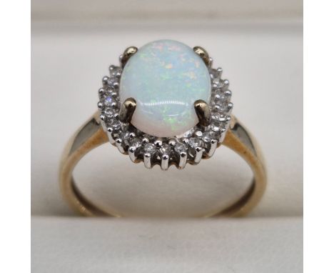 9ct yellow gold, opal and diamond stone ring. Large cabochon opal gem stone surrounded by round cut diamonds. 2.75Grams. Ring