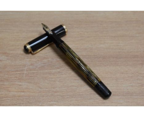 A Pelikan 400 piston fill fountain pen in tortoise shell striped with black cap having Pelikan 14C 585 OM nib.&nbsp;Condition