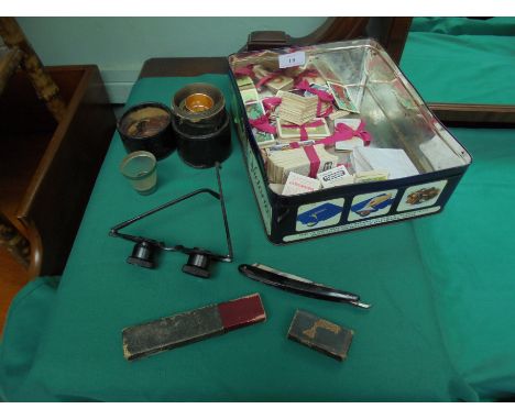 Tin containing a variety of cigarette and tea cards, cut throat razor in original case, binocular styled glasses, leather cir