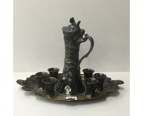 An art nouveau WMF white metal liqueur set and tray comprising decanter, six tots and tray, decorated in a trailing stylised 