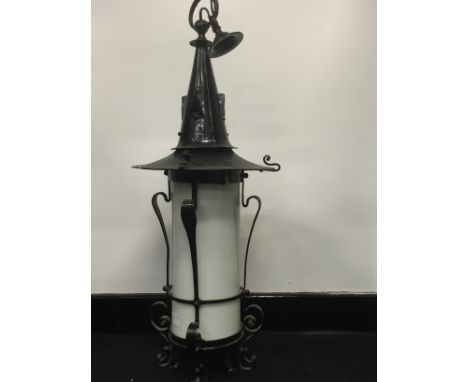 A large Arts & Crafts black painted metal porch lantern with original opaque white glass shade (71cm overall).