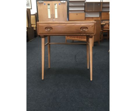 An Ercol Windsor Light Finish (479) elm and beech writing desk with single drawer, resting on tapered supports (68cm x 46cm).