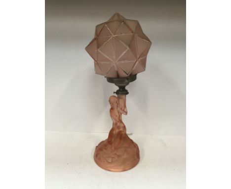 An Art Deco pink glass table lamp modelled as a Kneeling Naked Female Figure on rocky base with geometric pink glass shade. H