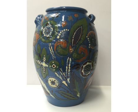 A large C. H. Brannam Barum twin handled vase/stick stand decorated in a stylised floral flower and leaf pattern on blue grou