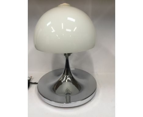 A modernist circular chrome based table lamp with opaque mushroom glass shade.