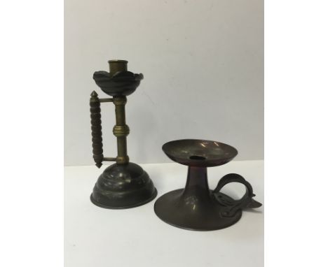 An Art Nouveau squat copper chamberstick with stylised leaf handle (9cm) together with an Arts & Crafts brass and copper cand