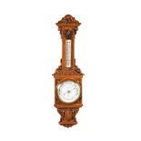 A LATE VICTORIAN CARVED OAK ANEROID WHEEL BAROMETER