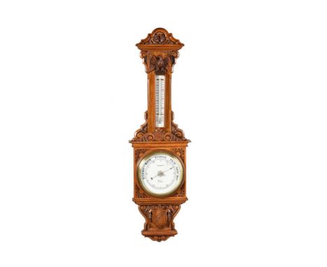 A LATE VICTORIAN CARVED OAK ANEROID WHEEL BAROMETERR. AND J. BECK, LONDON, CIRCA 1895The 8 inch circular glazed ceramic regis