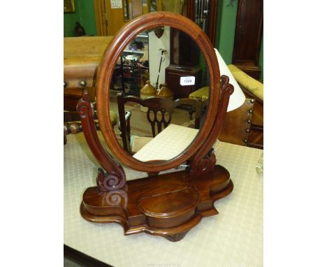 A Mahogany framed oval Swing Mirror standing on a shaped base with a central hinged lidded trinket well, 21" wide x 23 3/8" h