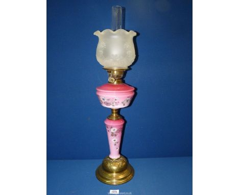 An opaque cranberry glass Oil Lamp with hand painted flowers and frosted glass shade, 30'' tall.