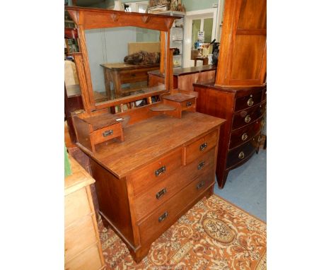 An Oak Dressing Chest having two long and two short drawers, the swing mirror raised on shelves with trinket drawers, 42'' wi