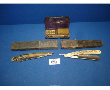 Two cut throat razors and a travelling safety razor.