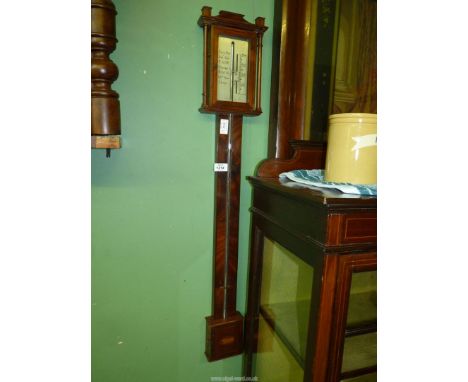 A Mahogany framed Stick Barometer, the upper glazed door providing access to the silvered scale and with a lower inlaid detai