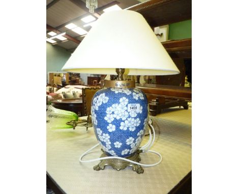 A prunus pattern blue and white table lamp with brass base and fabric shade.
