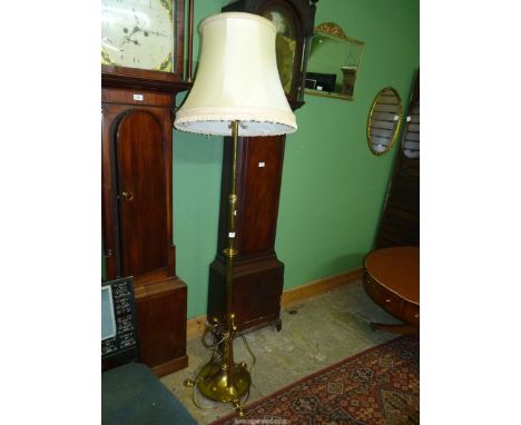 An Arts and Crafts brass oil standard Lamp converted to electric with cream fringed shade 73" tall.