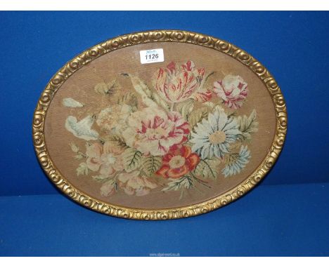 An oval wool work floral spray tapestry in moulded frame  17 1/2" wide x 13 3/4".
