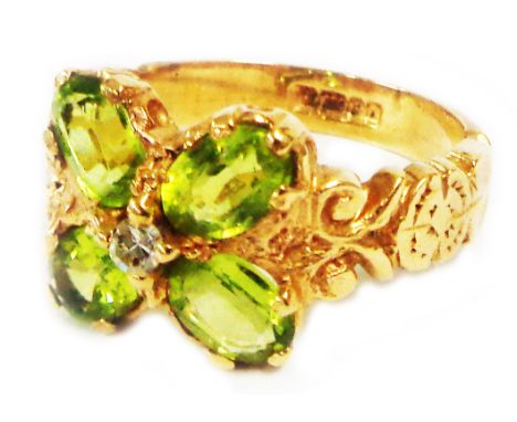 A 375 (9ct.) gold Edwardian style ring, set with four oval peridots, tiny central diamond and decorated shoulders - size P 1/