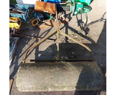 A large antique garden roller with wrought iron handle