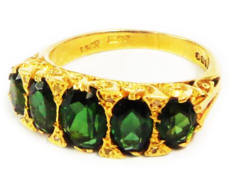An 18ct. gold ring, set with five graduated oval green garnets - size O