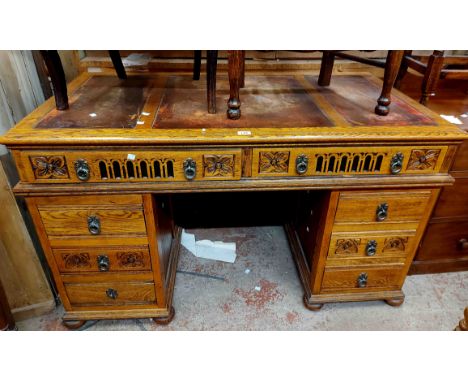 A 1.37m 20th Century light oak twin pedestal desk with long frieze drawer and six flanking pedestal drawers, set on bun feet