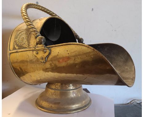 A late 19th Century Aesthetic Movement brass coal scuttle of helmet form with shovel