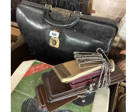 A vintage black leather doctor's bag containing two tie presses, etc.