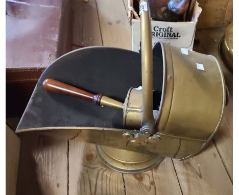An early 20th Century brass coal scuttle of helmet form with shovel