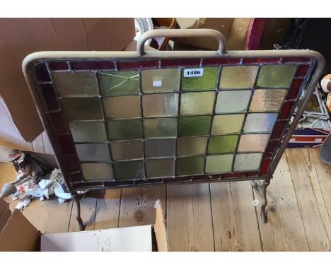 An early 20th Century brass fire screen with stained leaded glass panels