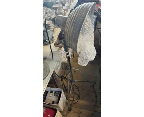 A vintage floor standing photographer's light, set on folding tripod base
