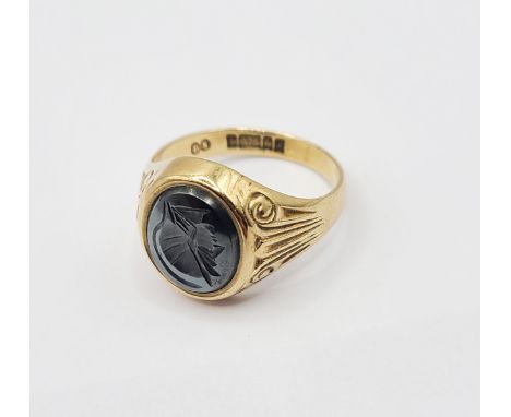 A 375 (9ct.) gold signet ring, with hematite intaglio panel and decorated shoulders - size Q 1/2