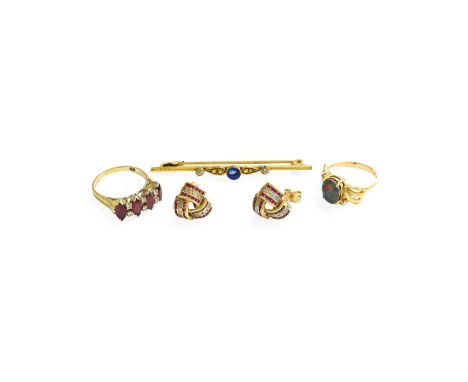 A Ruby and Diamond Ring, four marquise cut rubies spaced by pairs of round brilliant cut diamonds, in white claw settings, to