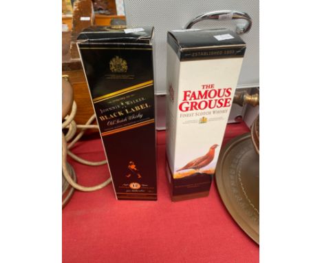 A bottle of Black label johnny walker old scotch whisky along with The Famous grouse scotch whisky 