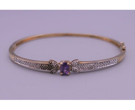 A 9 ct gold diamond and amethyst bangle. 6.5 cm wide. 7.6 grammes total weight.