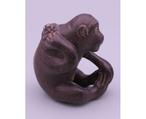 A wooden netsuke formed as a monkey. 4.5 cm high.
