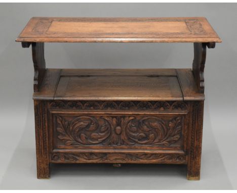 A carved oak monk's bench. 91 cm wide.