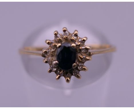 An 18 K gold sapphire and diamond cluster ring. Ring size N/O. 2 grammes total weight.