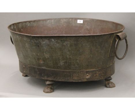 An antique twin handled metal planter with paw feet. 78 cm wide.